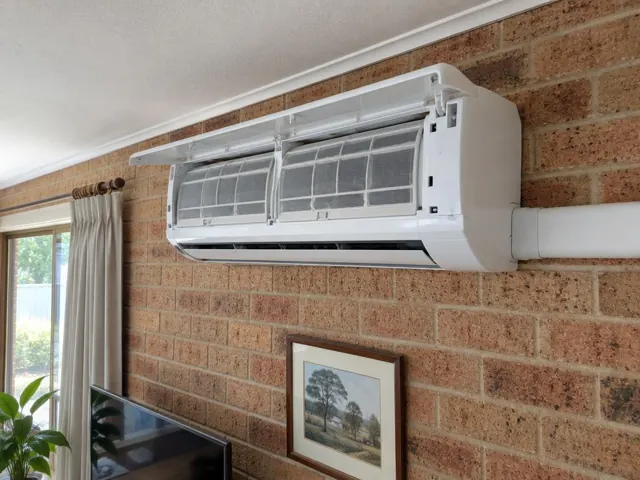 Open split system on a brick wall with clean filters visible above a living room in Salisbury North